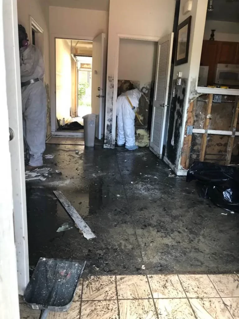 Interior of a water-damaged home with cleanup crews