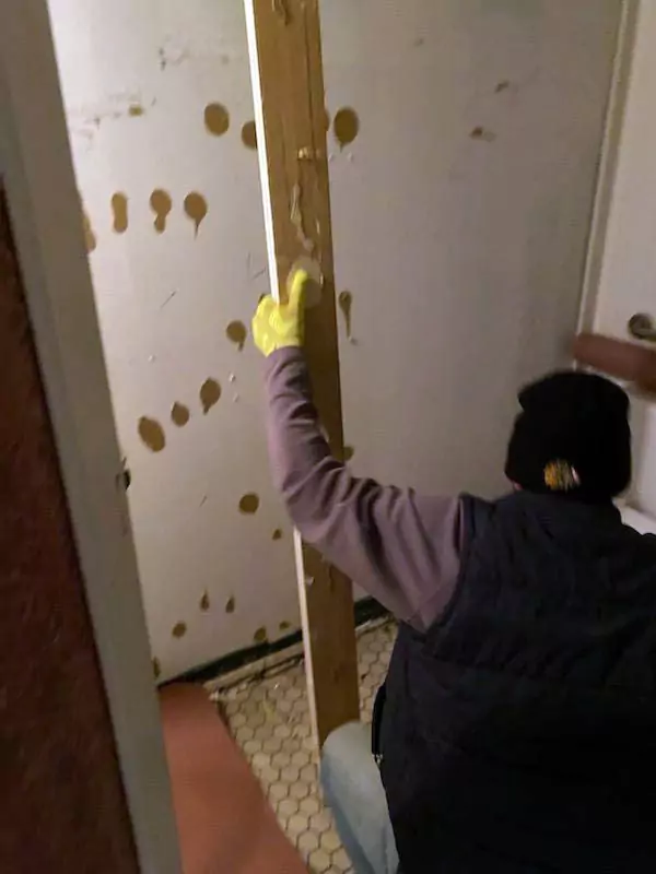 Construction worker installing a wooden post.