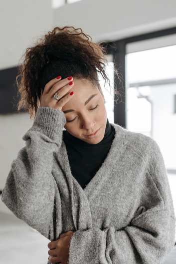 Woman with a headache indoors, a common symptom of mold exposure