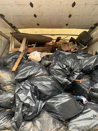 Junk removal truck loaded with bagged household junk and old furniture in Chicago